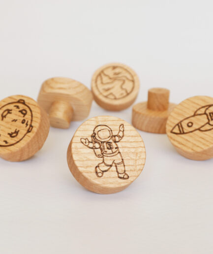 knobs for children's with furniture featuring laser-engraved designs of the moon, Saturn, Earth, an astronaut, the sun, and a rocket