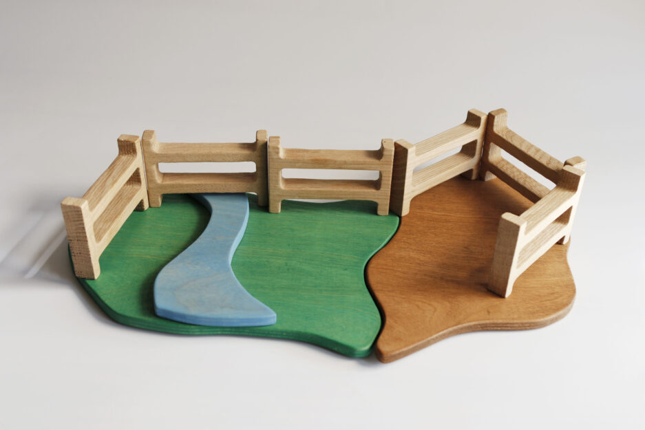 Beautifully crafted wooden nature playset featuring seasonal trees and a winding blue river