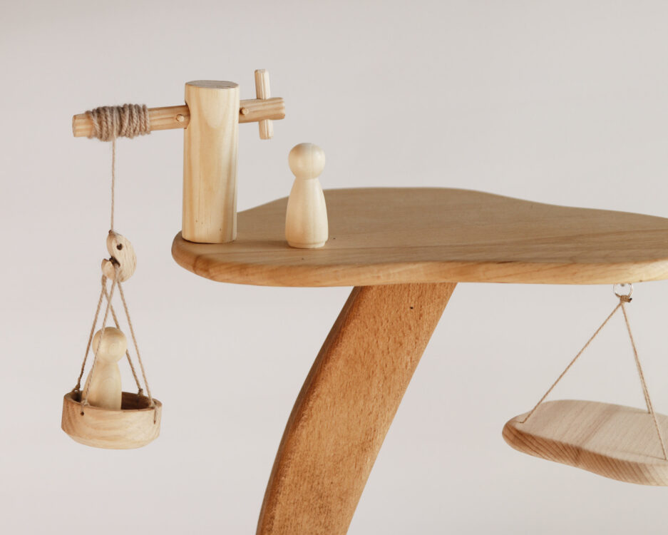 Close-up of the wooden figurines and pulley basket on the treehouse structure, highlighting fine details