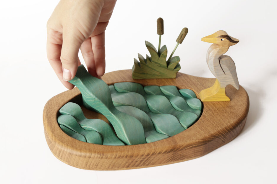 Close-up of a natural wood heron and vibrant green water pieces