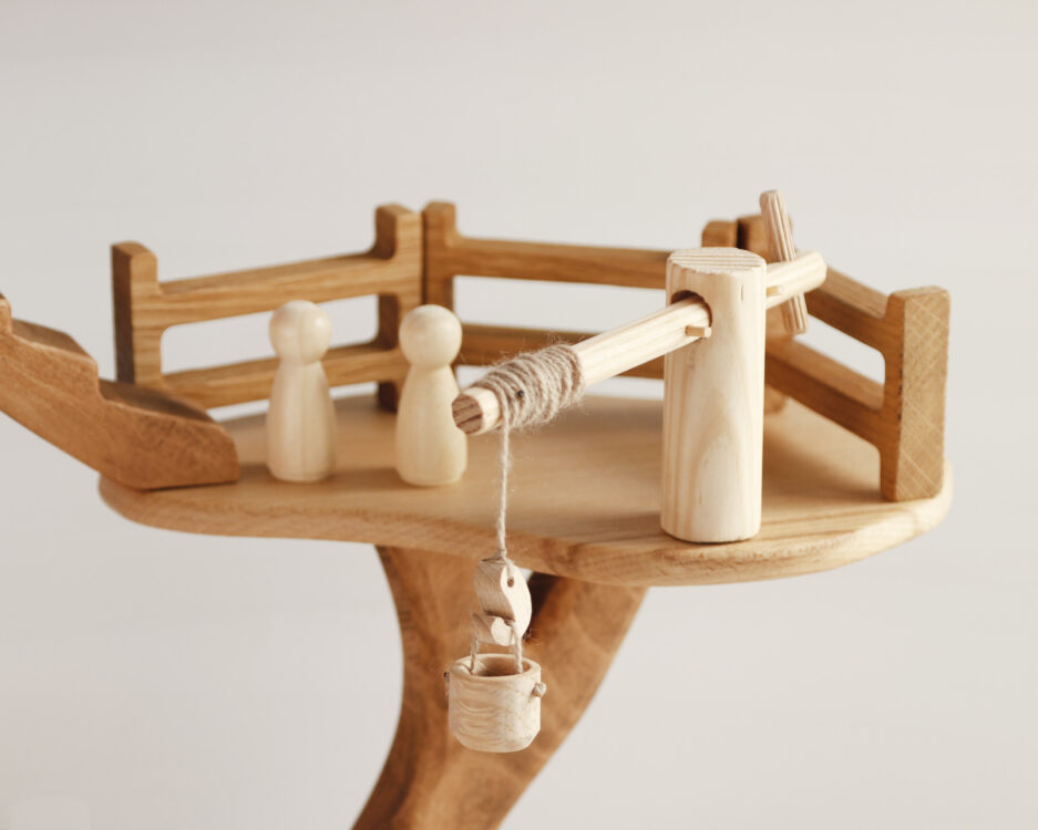 Side view showing multiple play levels and accessories like the seesaw and winding rope winch
