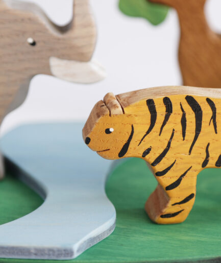 drewniana figurka tygrysa i słonia nad strumieniem