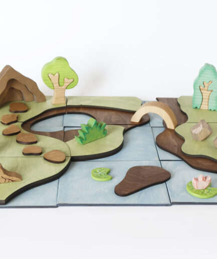 Wooden woodland playscape with modular landscape, river, bridge, trees and handmade details